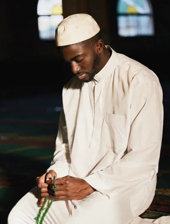 Man in traditional attire holding an investment notebook