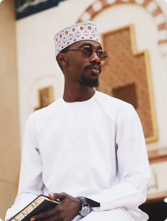 Man in traditional attire holding an investment notebook